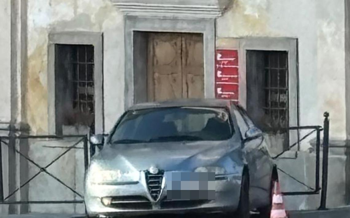 Cede il freno a mano: auto attraversa la rotonda e finisce contro la ringhiera dell'ex chiesa