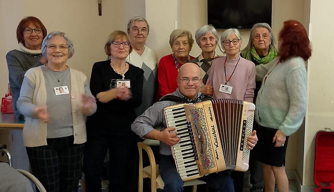 Panettoni e fisarmonica: gli auguri delle volontarie, in Casa di riposo