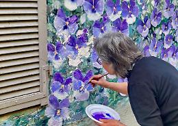 Teresita Terreno restaura il suo murales floreale, a Dogliani Castello