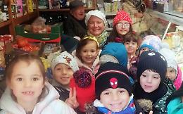 Piccoli artisti decorano il negozio del paese per Natale