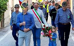 Una bimba del paese depone un mazzo di fiori, nel ricordo di chi non c'&egrave; pi&ugrave;