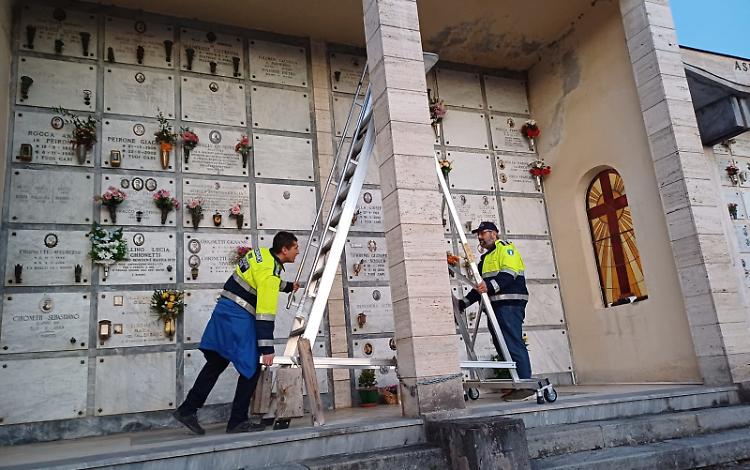 Sistemazione delle tombe in sicurezza: i volontari aiutano i cittadini, al cimitero